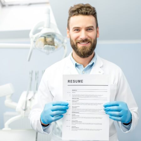 Professional dentist holding resume for a new job standing at the dental office