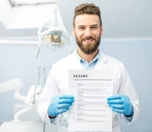 Professional dentist holding resume for a new job standing at the dental office