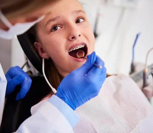 Part of orthodontist examining child's teeth in dentist's office