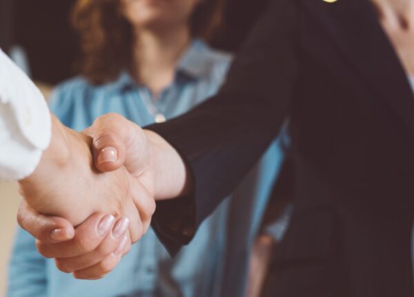 Business people shaking hands in the office. Successful partnership, meeting room conference.