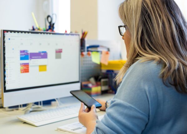 Female child therapist in an office during a phone call, using online calendar to schedule patients appointments. Calendar Planner Organization Management Concept.