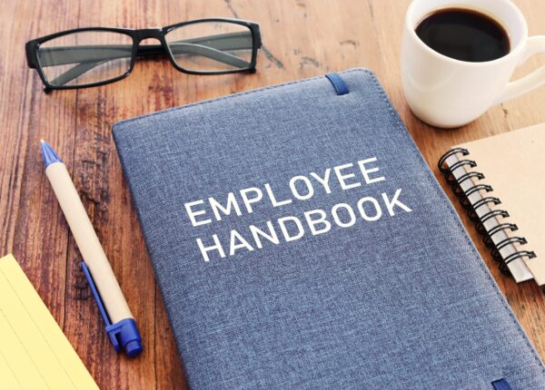 Concept image of employee handbook over wooden office table. top view