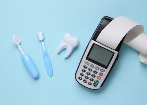 Toy dentist tools, payment terminal on a blue background. Dental care