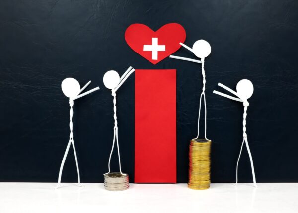 Stick figure reaching for a red heart shape with cross cutout while stepping on stack of coins. Healthcare, medical care and hospital access inequality concept.