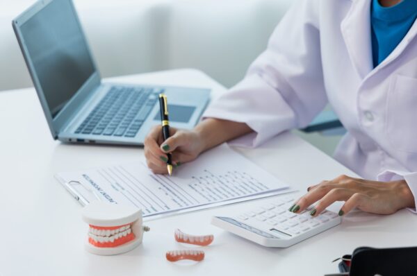 oral dentistry Female dentist in machine talking with male patient on table in clinic, dental model, dental health care according to prescription