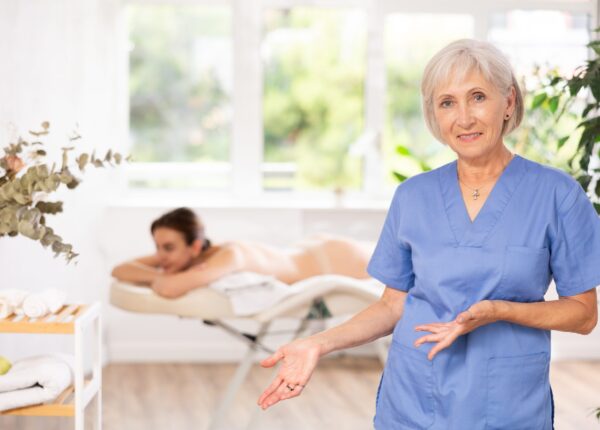 In spa office there is elderly woman nurse dressed in medical uniform, suit. Advertising poster, banner for salon of cosmetology and massage services