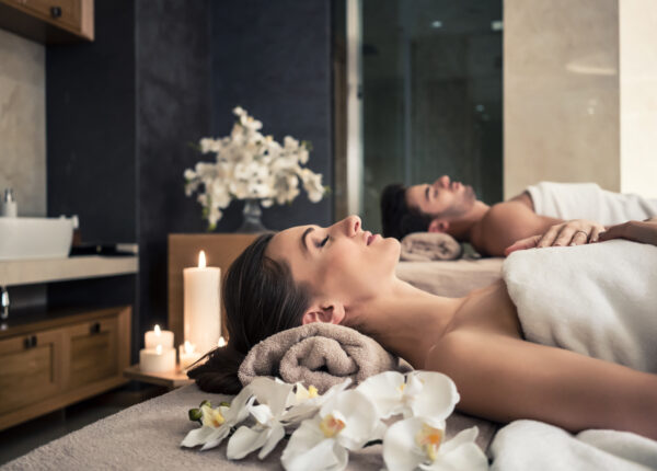 Young man and woman lying down on massage beds at Asian luxury spa and wellness center