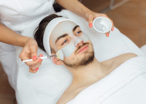 Unshaven man having cosmetic mask care in spa salon, side, top view - Image