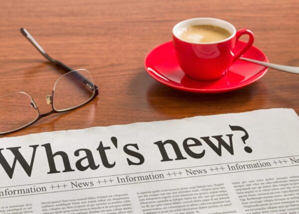 a newspaper with a cup of coffee and glasses on a table